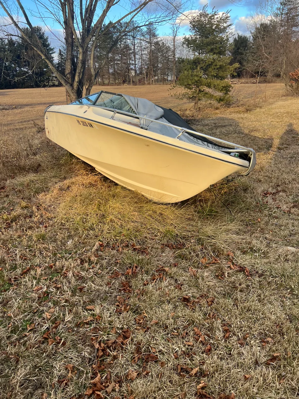 Bow of a yellow runabout resting on dry ground