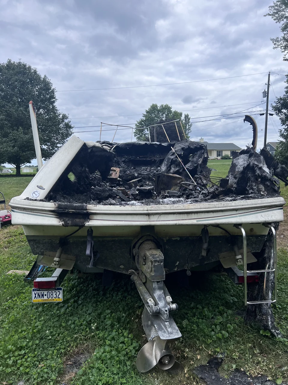 Damaged open hull with dark debris around an outboard engine