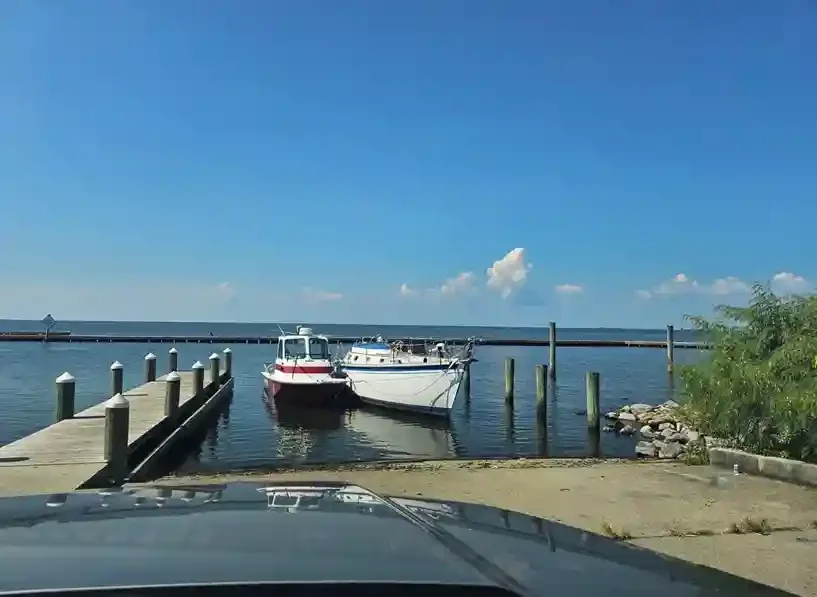 Motorboat at the end of a launching ramp beside wooden piers