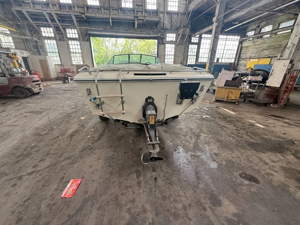Open motorboat and trailer inside an industrial workshop