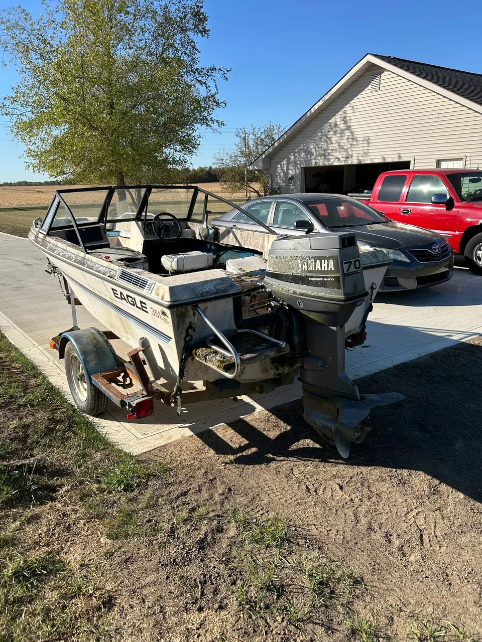 Outboard engine and stern of a boat parked beside a pickup
