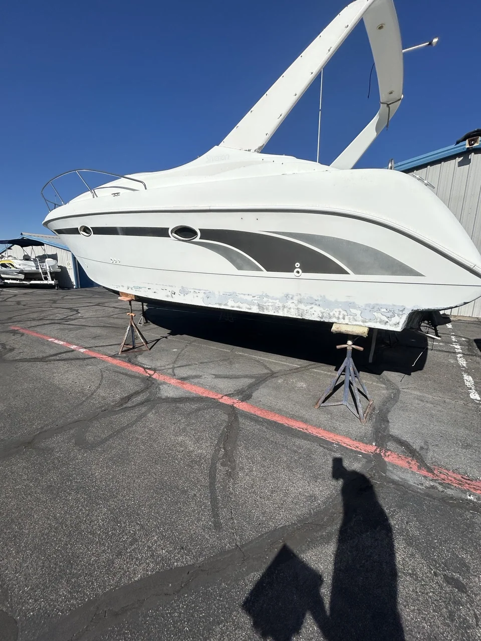 White motor yacht standing in a paved boatyard