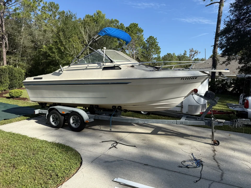 White runabout with a blue canopy on a driveway trailer